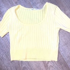A small yellow shirt with a low cut and indented stripes.